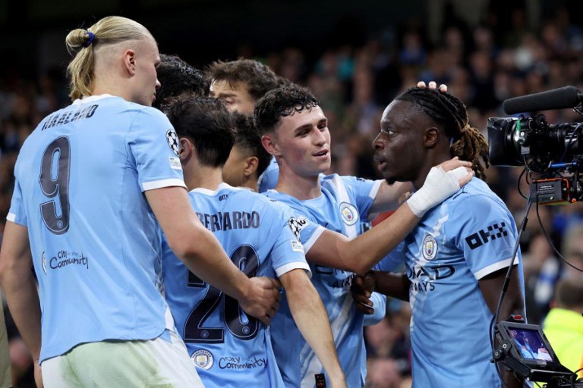 Manchester City's Belgian midfielder #11 Jeremy Doku (R) celebrates with teammates after scoring his team's second goal during the UEFA Champions League league stage football match between Manchester City and Napoli at the Etihad Stadium in Manchester, north west England, on September 18, 2025.  Darren Staples / AFP