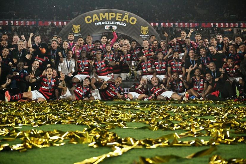 Flamengo's players celebrate with the Brasileirao trophy after winning the Brasileirao Serie A football match between Flamengo and Ceara at Maracana Stadium in Rio de Janeiro, Brazil, on December 3, 2025.  Mauro PIMENTEL / AFP