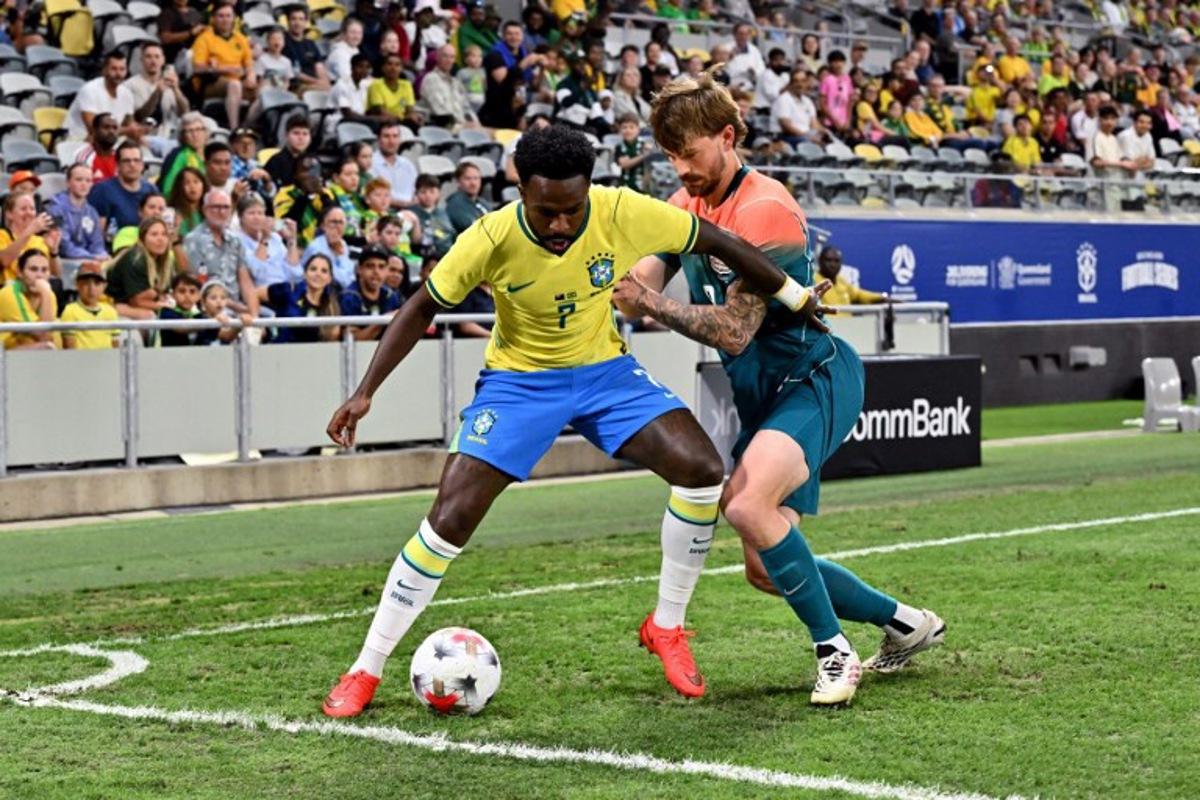 Brazil's Vinicius Junior (L) and Australia's Connor Metcalfe fight for the ball during the International friendly football match between Australia and Brazil at Queensland Country Bank Stadium in Townsville on September 25, 2026.  SAEED KHAN / AFP
