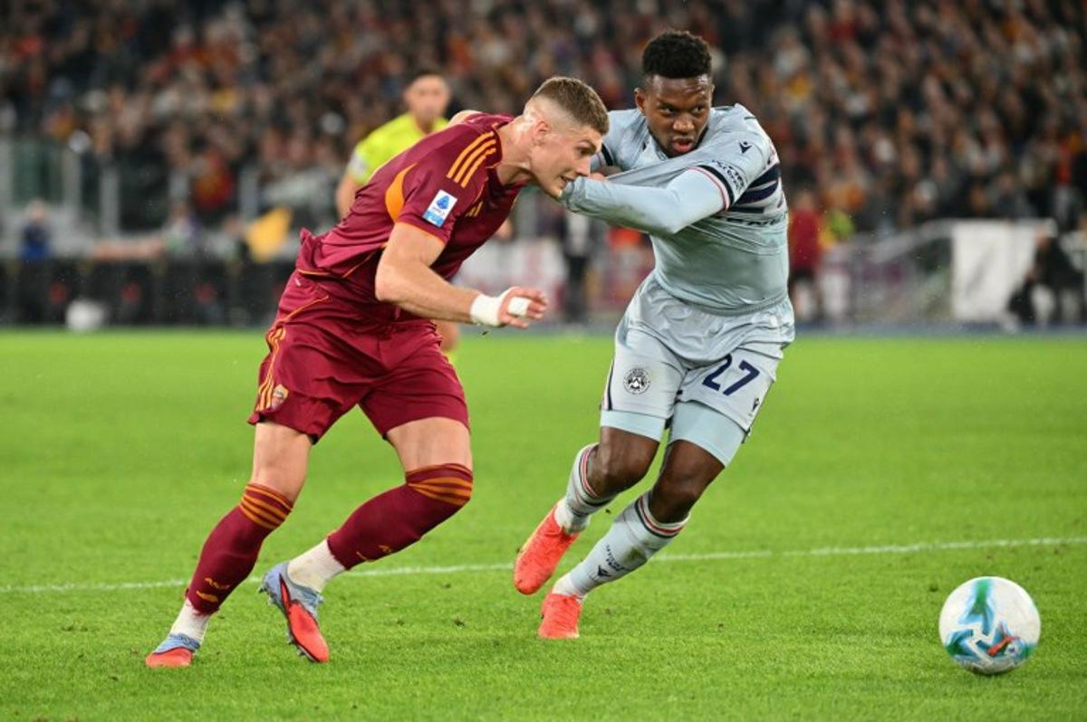 Roma's Ukrainian forward #09 Artem Dovbyk fights for the ball with Udinese's Belgian defender #27 Christian Kabasele during the Italian Serie A football match between AS Roma and Udinese at the Olympic Stadium in Rome on November 9, 2025.  Alberto PIZZOLI / AFP