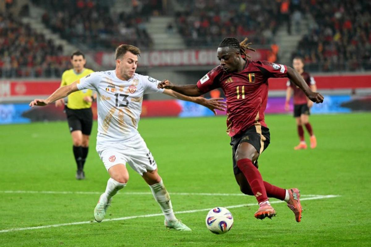 North Macedonia's defender #13 Stefan Despotovski (L) fights for the ball with Belgium's forward #11 Jeremy Doku during the FIFA World Cup 2026 Group J European qualification football match between Belgium and North Macedonia at the Planet Group Arena in Ghent, on October 10, 2025.  NICOLAS TUCAT / AFP