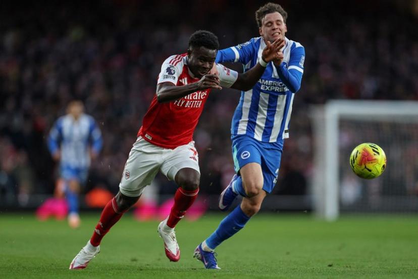Arsenal's English midfielder #07 Bukayo Saka (L) is challenged by Brighton's Belgian defender #29 Maxim De Cuyper (R) during the English Premier League football match between Arsenal and Brighton and Hove Albion at the Emirates Stadium in London on December 27, 2025.   Adrian Dennis / AFP