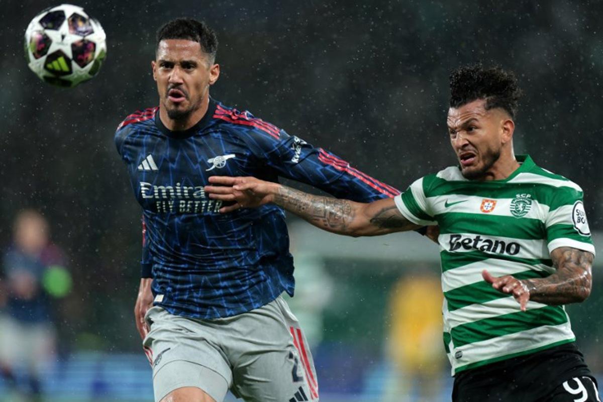 Arsenal's French defender #02 William Saliba (L) and Sporting Lisbon's Colombian forward #97 Luis Suarez fight for the ball during the UEFA Champions League quarter final first leg football match between Sporting CP and Arsenal at Jose Alvalade stadium in Lisbon on April 7, 2026.  PATRICIA DE MELO MOREIRA / AFP