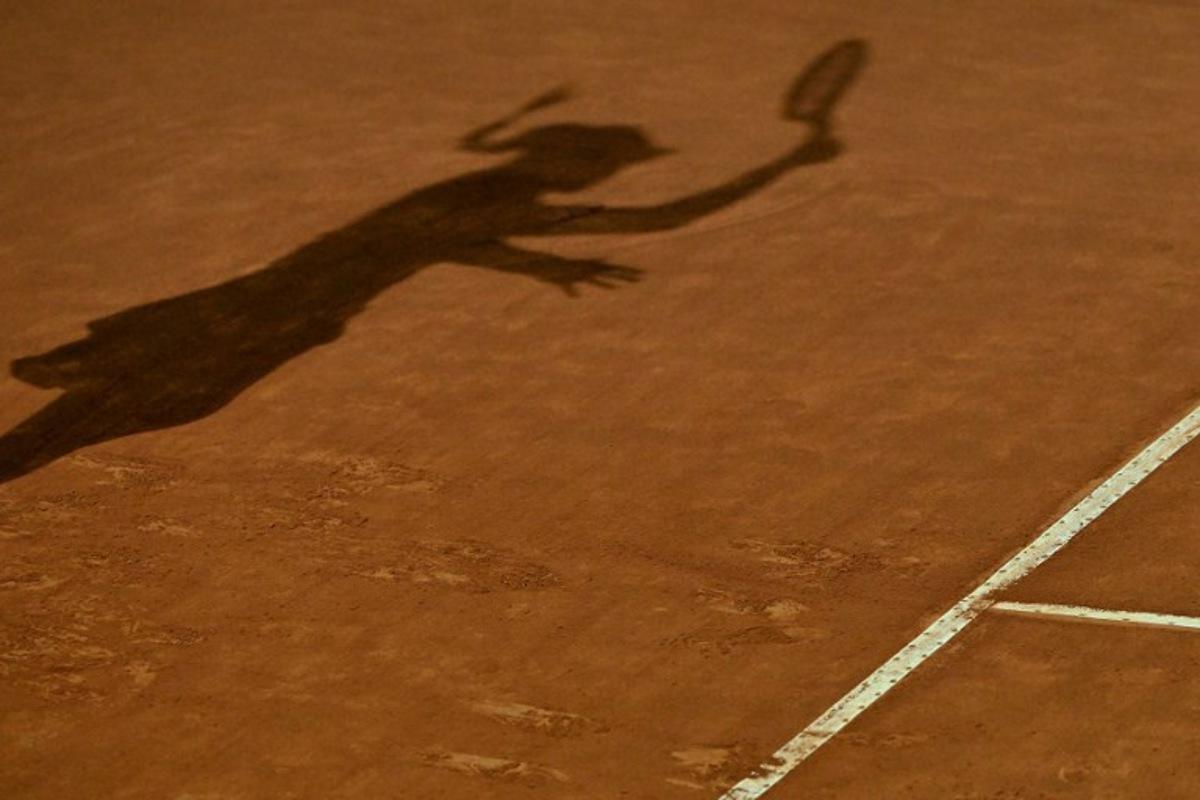 The shadow of Kazakhstan's Elena Rybakina is cast on the clay as she returns to Poland's Iga Swiatek during their quarterfinals match of the Women's WTA Rome Open tennis tournament on May 17, 2023 at Foro Italico in Rome.   Tiziana FABI / AFP
