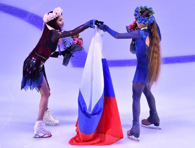 First place winner Russia's Alexandra Trusova (R) and second place winner Evgenia Medvedeva (L) hold the national flag after a rewarding ceremony at the Rostelecom Cup 2019 ISU Grand Prix of Figure Skating in Moscow on November 17, 2019.  Yuri KADOBNOV / AFP