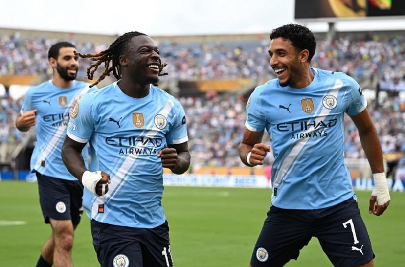 Manchester City's Belgian midfielder #11 Jeremy Doku celebrates after scoring the openin goal with teammate Egyptian striker #07 Omar Marmoush during the FIFA Club World Cup 2025 Group D football match between US Los Angeles FC and Brazil's CR Flamengo at the Camping World stadium in Orlando on June 24, 2025.  PATRICIA DE MELO MOREIRA / AFP