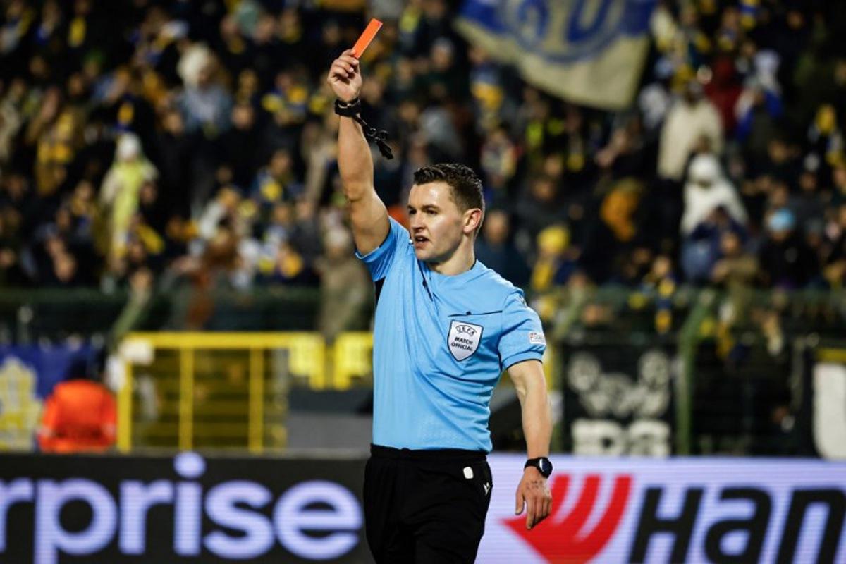Referee Nicholas Walsh holds a red card during the UEFA Europa League, league phase football match between Royale Union Saint-Gilloise and SC Braga at the King Baudouin Stadium in Brussels, on January 23, 2025.  Simon Wohlfahrt / AFP