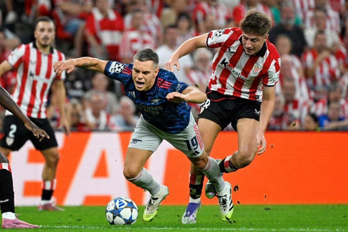 Arsenal's Belgian forward #19 Leandro Trossard falls as he fights for the ball with Athletic Bilbao's Spanish midfielder #18 Mikel Jauregizar Alboniga during the UEFA Champions League first round day 1 football match between Athletic Club Bilbao and Arsenal at the San Mames stadium in Bilbao on September 16, 2025.   ANDER GILLENEA / AFP