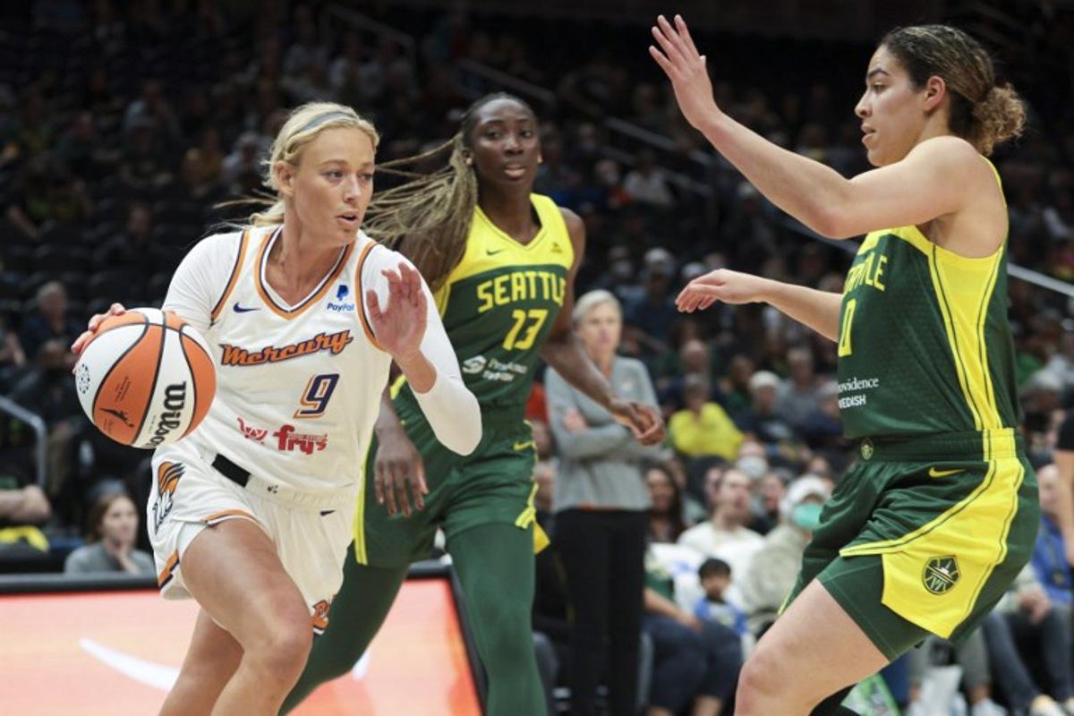 Phoenix Mercury guard Sophie Cunningham (L) drives to the basket as Seattle Storm center Ezi Magbegor (2nd L) and guard Kia Nurse (R) defend  during the WNBA preseason basketball game between Phoenix Mercury and Seattle Storm at Climate Pledge Arena in Seattle, Washington, on May 8, 2023.  Jason Redmond / AFP