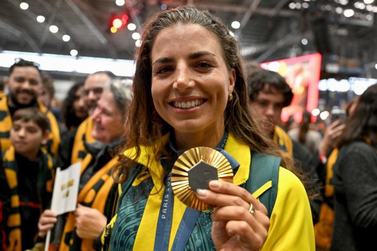 Australia's Jessica Fox, gold medallist in the women's canoe slalom kayak single and canoe single events, displays her medal during an event following her return from the Paris 2024 Olympic Games at the Sydney International Airport on August 14, 2024.   Saeed KHAN / AFP