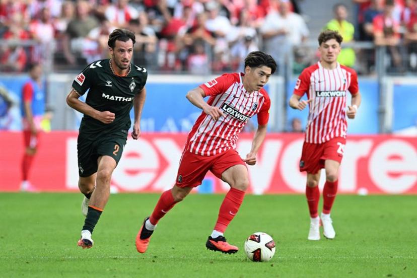 Bremen's Belgian defender #02 Olivier Deman and Freiburg's Japanese midfielder #14 Yuito Suzuki vie for the ball during the German first division Bundesliga football match between SC Freiburg and Werder Bremen in Freiburg, southern Germany, on August 30, 2026.  THOMAS KIENZLE / AFP