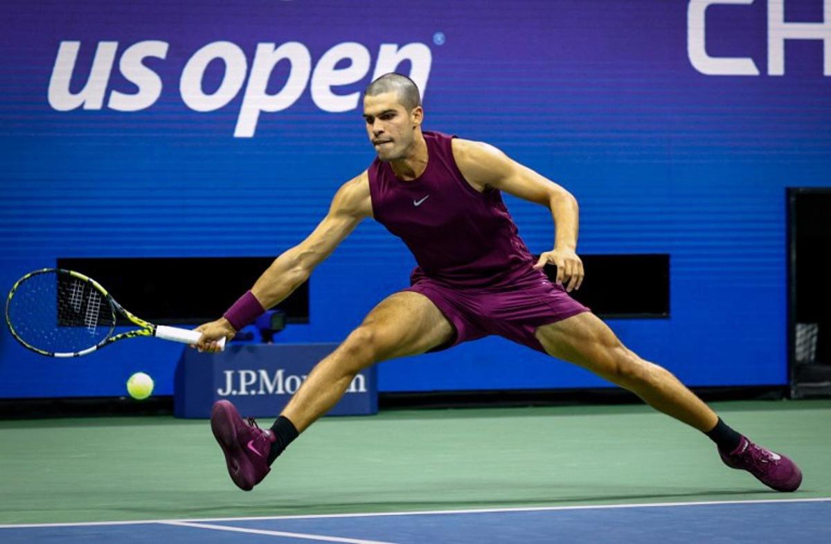 Spain's Carlos Alcaraz plays a forehand return to USA's Reilly Opelka during their men's singles first round tennis match on day two of the US Open tennis tournament at the USTA Billie Jean King National Tennis Center in New York City, on August 25, 2025.  Kena Betancur / AFP