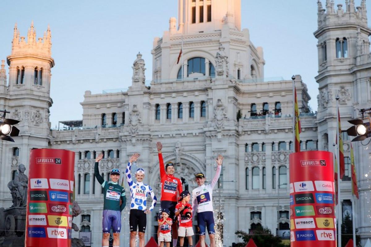 (From L) Team Alpecin's Kaden Groves, Team UAE's Jay Vine celebrates, overall leader Team Bora's Primoz Roglic and Team Lidl-Trek's Mattias Skjelmose celebrate on the podium after the last stage of the Vuelta a Espana, a 24,6 km time-trial race between Madrid and Madrid, on September 8, 2024. OSCAR DEL POZO / AFP
