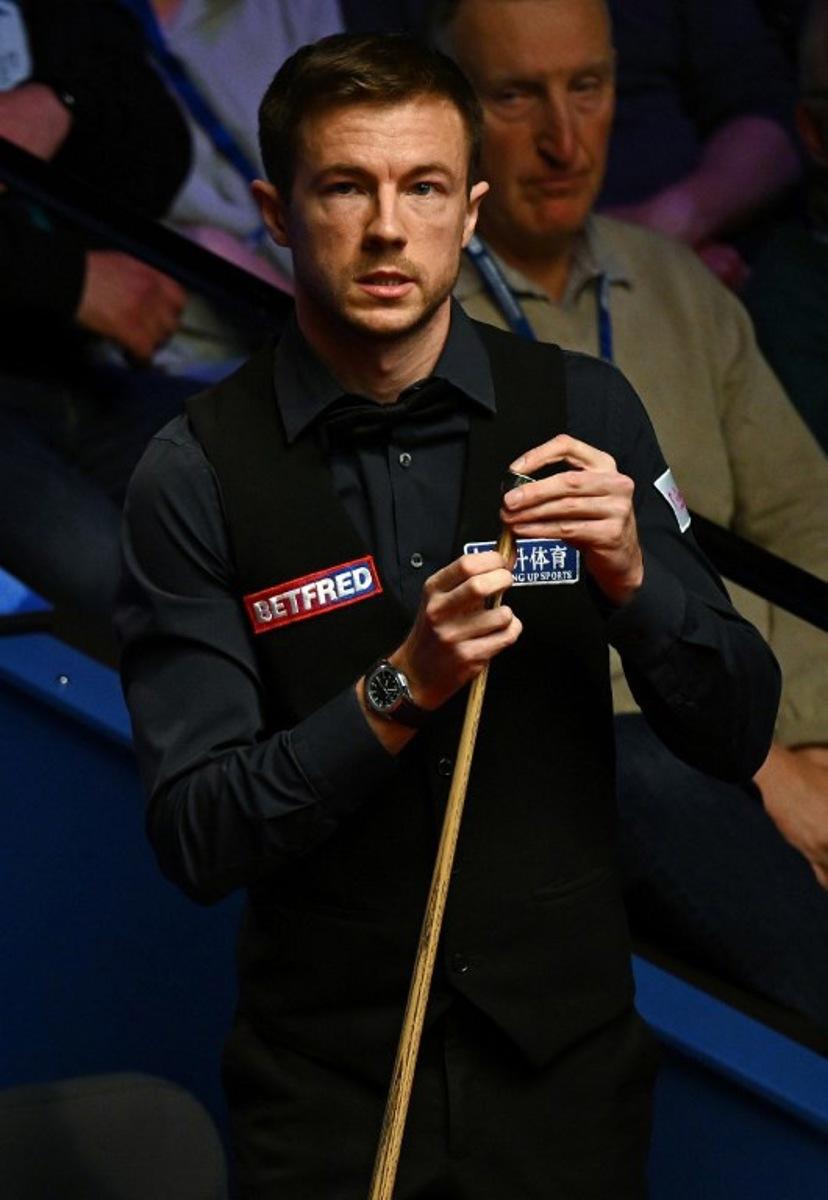 England's Jack Lisowski chalks his cue as he plays against Australia's Neil Robertson during their World Championship Snooker second round match at The Crucible in Sheffield, England on April 25, 2022. Paul ELLIS / AFP
