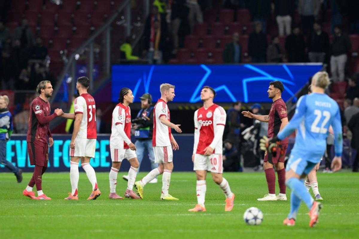 Ajax's players greet Galataray's players at the end of the UEFA Champions League, league phase day 4, football match between Ajax and Galatasaray at the Johan Cruijff ArenA in Amsterdam on November 5, 2025. JOHN THYS / AFP