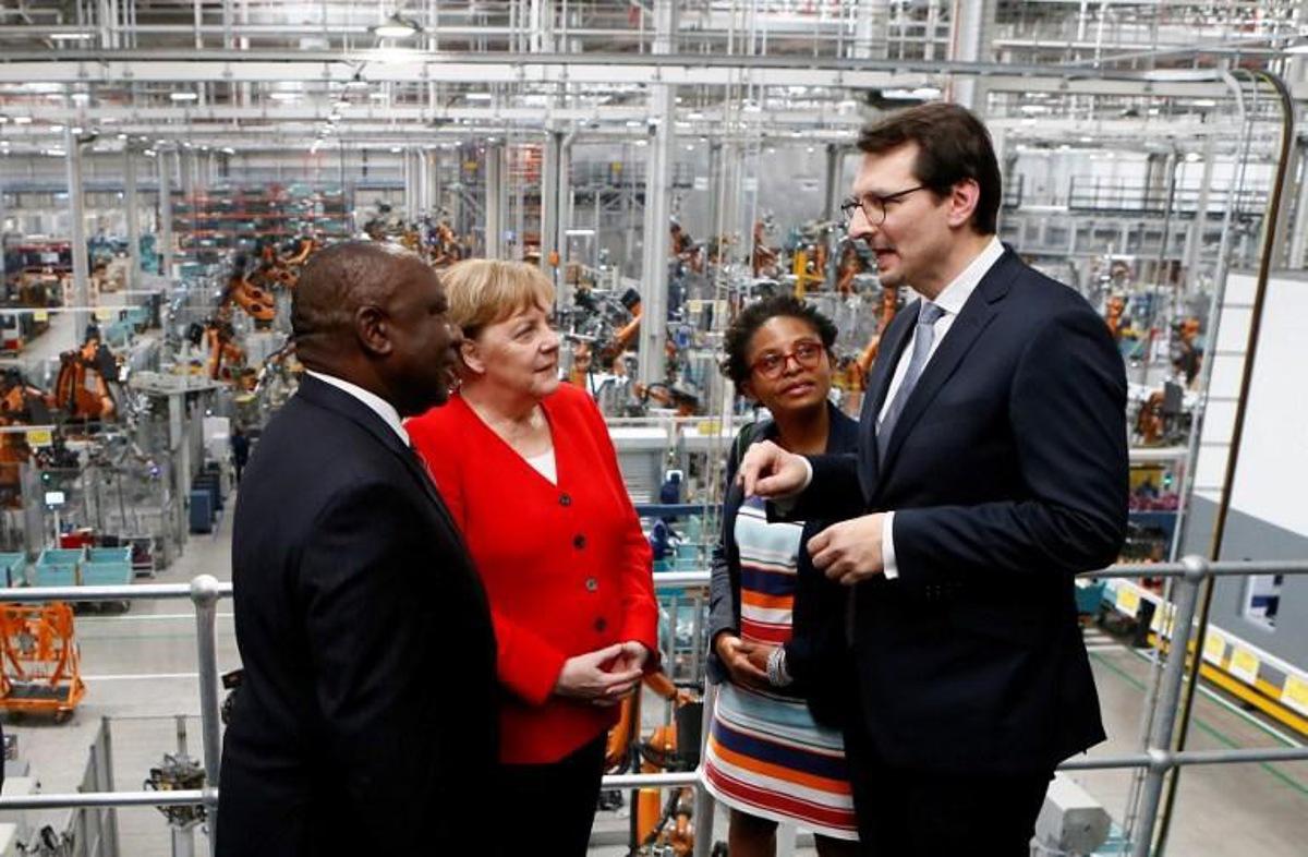 South Africa's President Cyril Ramaphosa (L), BMW Head of Productions Milan Nedeljkovic (R), German Chancellor Angela Merkel (2ndL) and South Africa's Minister of Small Business Development Khumbudzo Ntshavheni (2ndR), speak during a visit to the BMW Group production plant in Rosslyn, Pretoria on February 6, 2020. Phill Magakoe / AFP