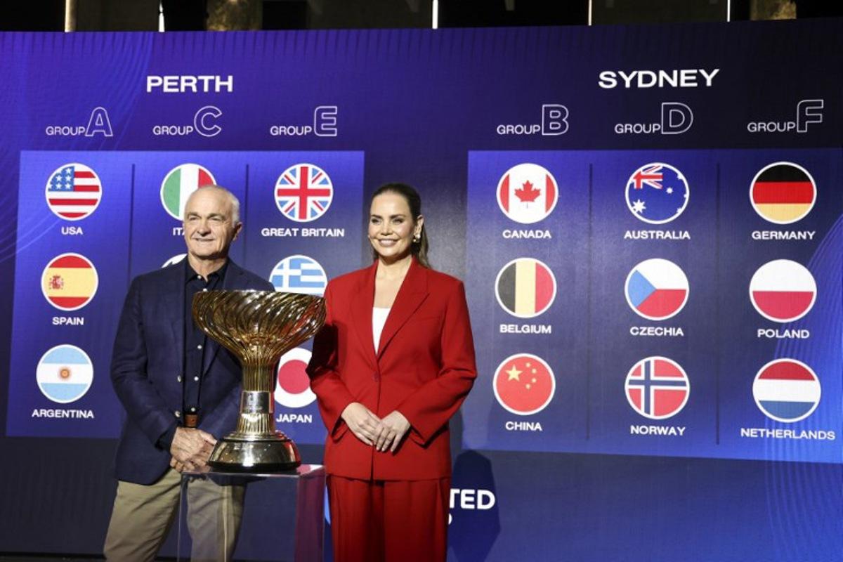 Former Australian tennis players Wally Masur (L) and Jelena Dokic pose for photographs with the United Cup trophy after participating in the official draw ceremony in Sydney on November 17, 2025. The United Cup mixed team tennis tournament will be held in January 2026 in Perth and Sydney. DAVID GRAY / AFP