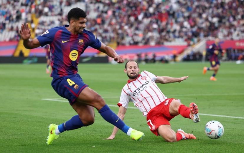 Barcelona's Uruguayan defender #04 Ronald Federico Araujo da Silva fights for the ball with Girona's Dutch defender #17 Daley Blind during the Spanish league football match between FC Barcelona and Girona FC at Estadi Olimpic Lluis Companys in Barcelona on October 18, 2025. Josep LAGO / AFP