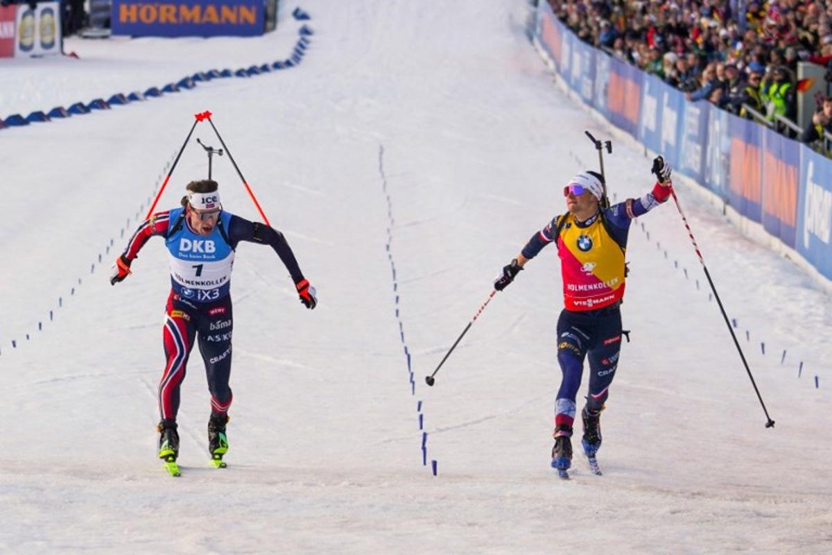 Norway's Sturla Holm Laegreid (L) crosses the finish line to win as France's Eric Perrot (R) comes in to place second during the men's 12,5km pursuit event of the IBU Biathlon World Cup in Holmenkollen, Oslo on March 21, 2026. Thomas Fure / NTB / AFP