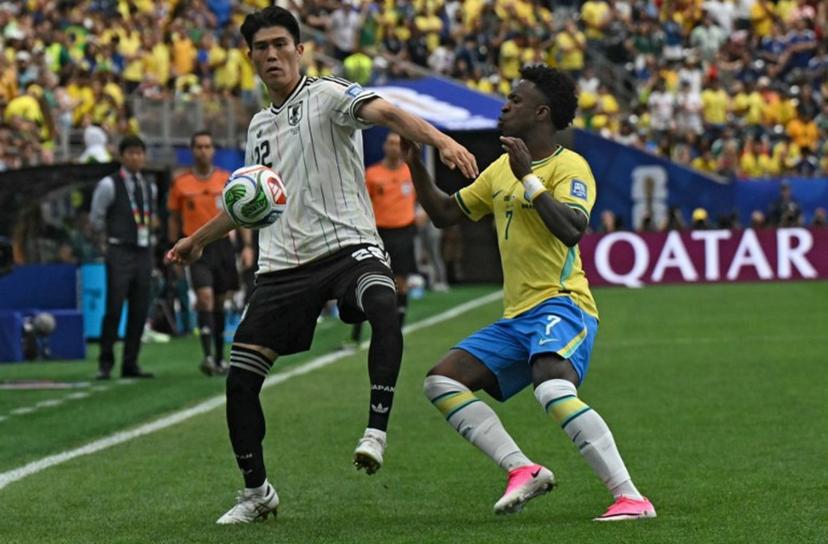 Japan's defender #22 Takehiro Tomiyasu (L) fights for the ball with Brazil's forward #07 Vinicius Junior during the 2026 World Cup round of 32 football match between Brazil and Japan at the Houston Stadium in Houston on June 29, 2026. RONALDO SCHEMIDT / AFP