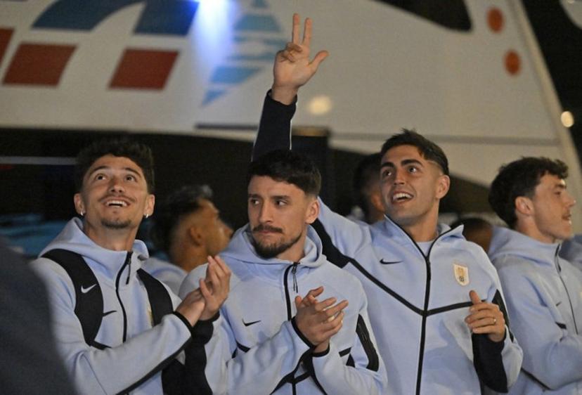(L to R) Uruguay's midfielder #15 Emiliano Martinez, Uruguay's defender #22 Joaquin Piquerez and Uruguay's goalkeeper #12 Santiago Mele acknowledge fans as the Uruguay national football team arrives at Carrasco International Airport ahead of its departure to Mexico for the FIFA 2026 World Cup football tournament, in Ciudad de la Costa, Canelones department, Uruguay, on June 9, 2026. Santiago Mazzarovich / AFP