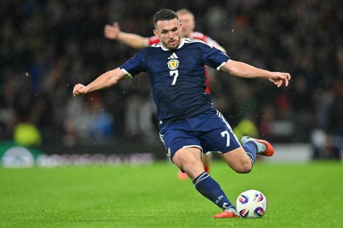 Scotland's midfielder #07 John McGinn crosses the ball during the FIFA World Cup 2026 European qualification football match between Scotland and Denmark at Hampden Park in Glasgow on November 18, 2025. ANDY BUCHANAN / AFP