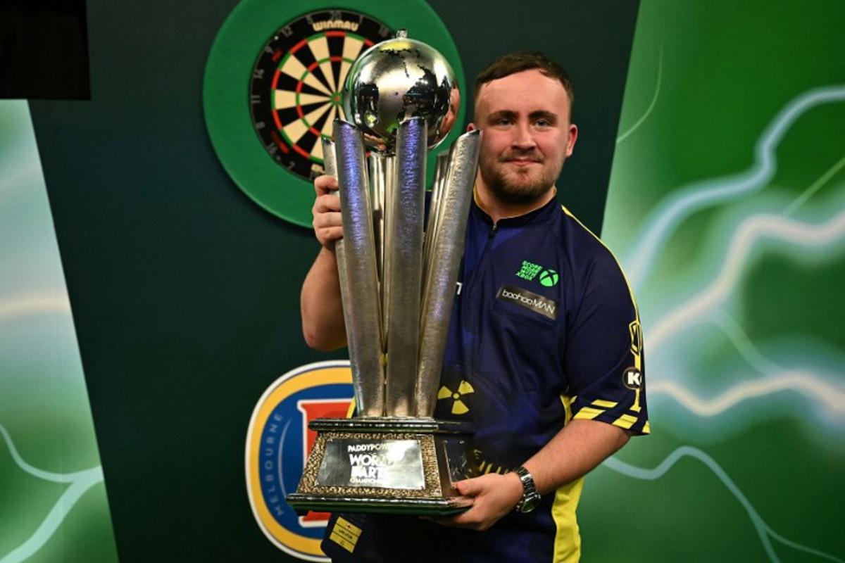 England's Luke Littler poses with the Sid Waddell Trophy after victory over Netherlands' Michael van Gerwen in the PDC World Darts Championship final, at Alexandra Palace in London on January 3, 2025. Luke Littler became darts' youngest world champion at just 17 after thrashing three-time winner Michael van Gerwen in front of an adoring home crowd at London's Alexandra Palace on Friday. This time there was no stopping "Luke the Nuke" as he stormed past Dutchman Van Gerwen by seven sets to three. Ben STANSALL / AFP