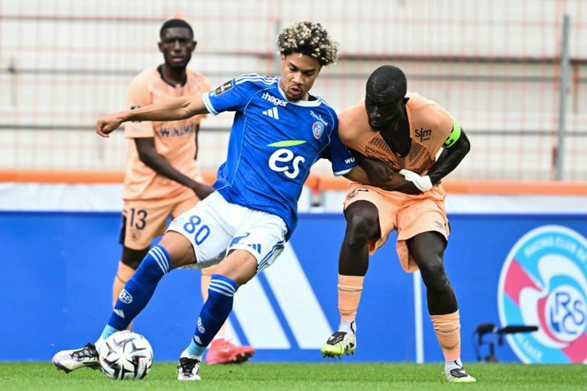 Strasbourg's French midfielder #80 Felix Lemarechal (L) fights for the ball with Le Havre's Senegalese defender #93 Arouna Sangante (R) during the French L1 football match between RC Strasbourg Alsace and Le Havre at the Stade de la Meinau in Strasbourg, eastern France, on September 14, 2025. SEBASTIEN BOZON / AFP