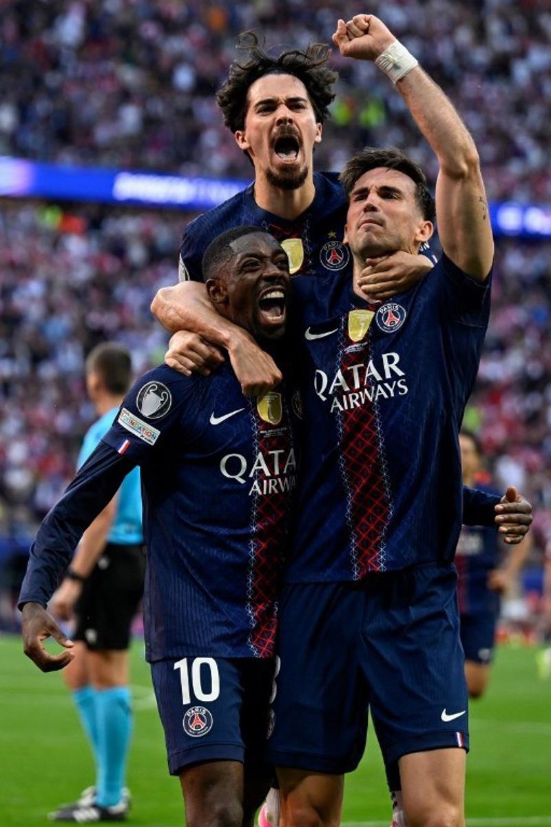 Paris Saint-Germain's French forward #10 Ousmane Dembele (L) celebrates after scoring his team's first goal after penalty with Paris Saint-Germain's Portuguese midfielder #17 Vitinha (C) and Paris Saint-Germain's Spanish midfielder #08 Fabian Ruiz during the UEFA Champions League final football match between Paris Saint-Germain (PSG) and Arsenal FC at the Puskas Arena in Budapest on May 30, 2026. INA FASSBENDER / AFP