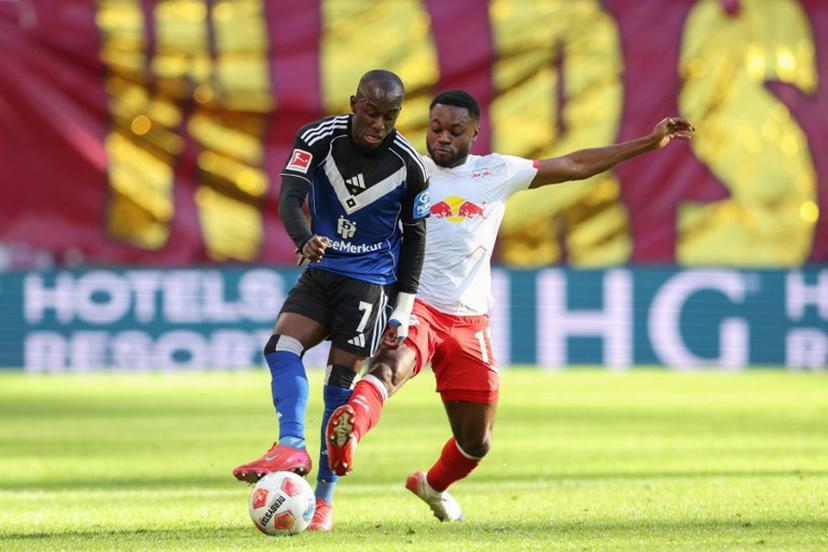 Hamburg's French-Ivorian forward #07 Jean-Luc Dompe (L) and Leipzig's German midfielder #17 Ridle Baku vie for the ball during the German first division Bundesliga football match RB Leipzig v Hamburg SV in Leipzig, eastern Germany on October 18, 2025. Ronny HARTMANN / AFP