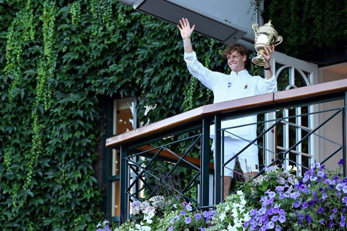 Italy's Jannik Sinner waves from the balcony after winning the men's singles final tennis match against Germany's Alexander Zverev on the last day of the 2026 Wimbledon Championships at The All England Lawn Tennis and Croquet Club in Wimbledon, southwest London, on July 12, 2026. Kirill KUDRYAVTSEV / AFP