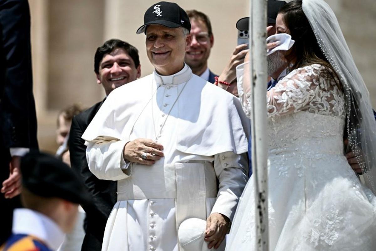 Pope Leo XIV (C) reacts wearing a Chicago White Sox baseball team cap as he meets newly wedded couples during the weekly general audience in St Peter's Square at the Vatican on June 11, 2025. Filippo MONTEFORTE / AFP