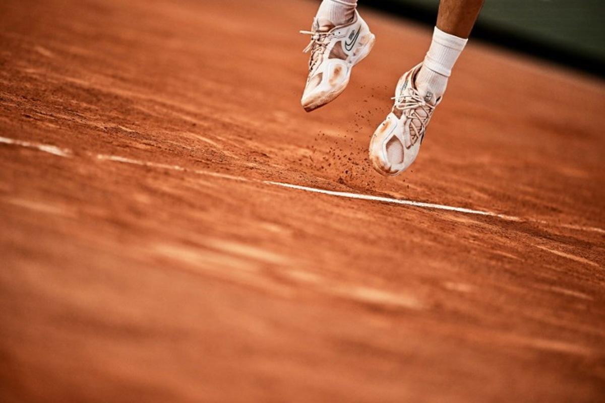 Clay falls from the sneakers of Spain's Carlos Alcaraz Garfia as he plays against Greece's Stefanos Tsitsipas during their men's singles quarter final match on day ten of the Roland-Garros Open tennis tournament at the Court Philippe-Chatrier in Paris on June 6, 2023. JULIEN DE ROSA / AFP