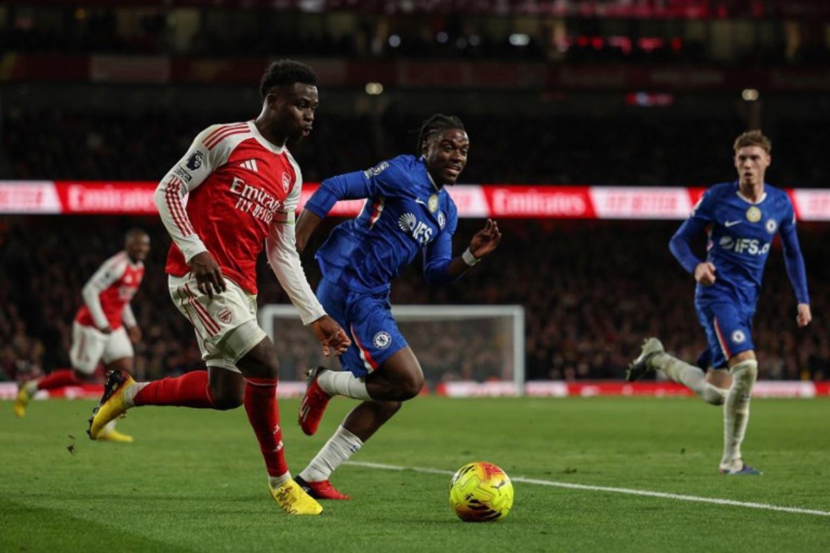 Chelsea's English midfielder #10 Cole Palmer (R) and Chelsea's Belgian midfielder #45 Romeo Lavia (C) challenge Arsenal's English midfielder #07 Bukayo Saka (L) during the English Premier League football match between Arsenal and Chelsea at the Emirates Stadium in London on March 1, 2026. Adrian Dennis / AFP