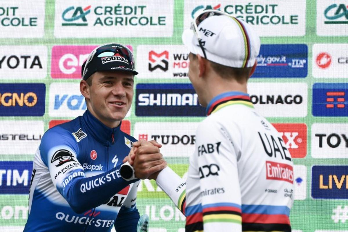Second-placed Soudal Quick-Step team's Belgian rider Remco Evenepoel (L) shakes hands with winner UAE Team Emirates team's Slovenian rider Tadej Pogacar (R) on the podium after the 118th edition of the Giro di Lombardia (Tour of Lombardy), a 252km cycling race from Bergamo to Como on October 12, 2024. Marco BERTORELLO / AFP