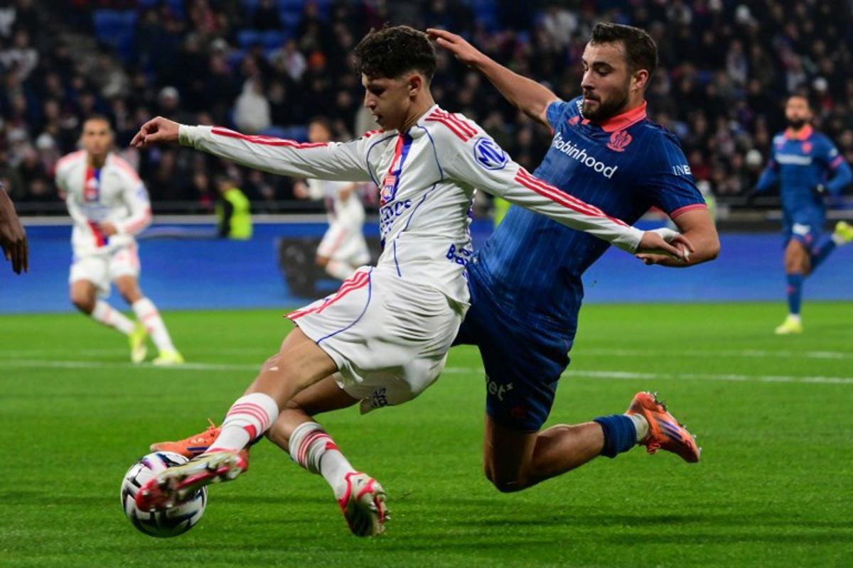 Lyon's French midfielder #44 Khalis Merah (L) and Nice's Belgian midfielder #24 Charles Vanhoutte (R) fight for the ball during the French L1 football match between Olympique Lyonnais (OL) and OGC Nice at the Groupama Stadium in Decines-Charpieu, central-eastern France, on February 15, 2026. OLIVIER CHASSIGNOLE / AFP