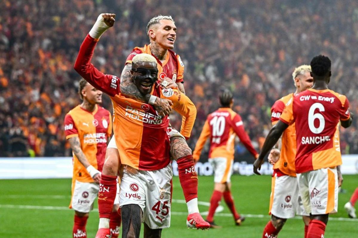 Galatasaray's Uruguayan midfielder #34 Lucas Torreira (2nd L) celebrates with Galatasaray's Nigerian forward #45 Victor Osimhen (L) after scoring his team's third goal during the Turkish Super lig football match between Fenerbahce and Galatasaray at the Rams Park stadium in Istanbul, on April 26, 2026. Yasin AKGUL / AFP