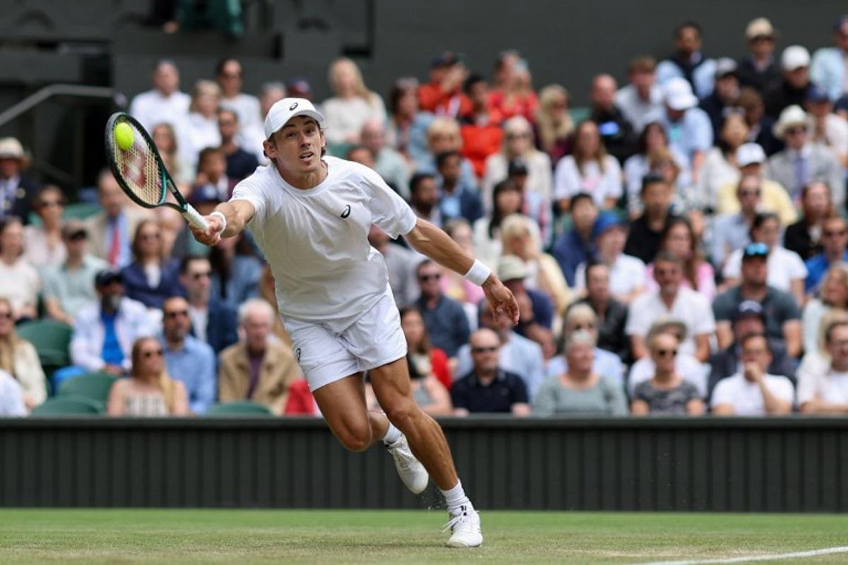 Australia's Alex De Minaur plays a forehand return to Serbia's Novak Djokovic during their men's singles fourth round tennis match on the eighth day of the 2025 Wimbledon Championships at The All England Lawn Tennis and Croquet Club in Wimbledon, southwest London, on July 7, 2025. Adrian Dennis / AFP