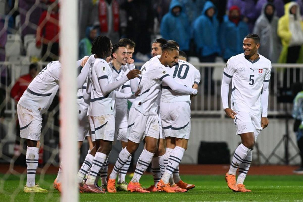 Switzerland's midfielder #17 Ruben Vargas (C) celebrates with teammates after scoring the opening goal during the FIFA World Cup 2026 European qualification Group B football between Kosovo and Switzerland at the Fadil Vokrri Stadium in Pristina, on November 18, 2025. Armend NIMANI / AFP
