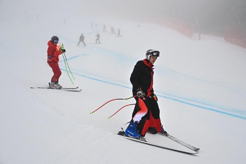 Switzerland's Marco Odermatt (R) inspects the course in the fog before the men's super-G alpine skiing event during the Milano Cortina 2026 Winter Olympic Games at the Stelvio Ski Centre in Bormio (Valtellina) on February 11, 2026. Fabrice COFFRINI / AFP