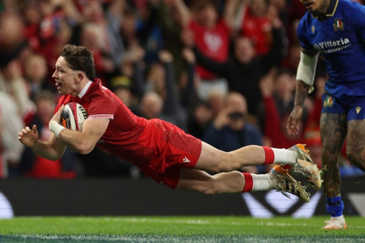 Wales' fly-half Dan Edwards dives over the line to score their fourth try during the Six Nations international rugby union match between Wales and Italy at the Principality Stadium in Cardiff, southern Wales on March 14, 2026. Adrian Dennis / AFP