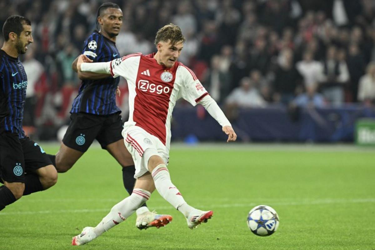 Ajax's Belgian forward #11 Mika Godts shoots the ball during the UEFA Champions League first round day 1 football match between Ajax Amsterdam and Inter Milan, at the Johan Cruijff ArenA in Amsterdam, on September 17, 2025. NICOLAS TUCAT / AFP