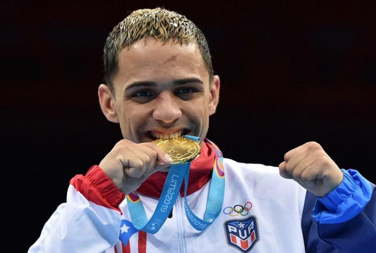 Puerto Rico's Oscar Collazo celebrates on the podium with his gold medal after defeating Colombia's Yuberjen Martinez in the Men's Light Fly (46-49kg) Final Bout of the Boxing competition Lima 2019 Pan-American Games at the Miguel Grau Coliseum in Callao on August 2, 2019. Cris BOURONCLE / AFP