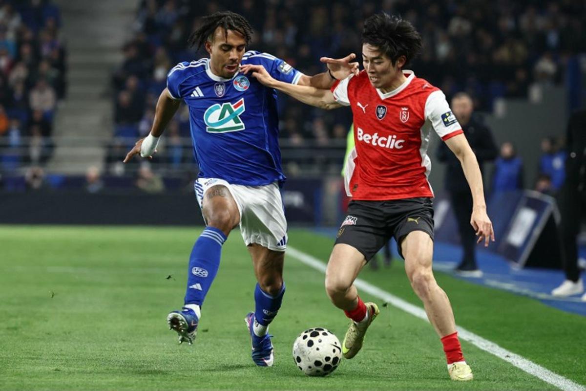 Strasbourg's Ivorian defender #22 Guela Doue (L) fights for the ball with Reims' Japanese forward #17 Keito Nakamura during the French Cup quarter final football match between RC Strasbourg Alsace and Stade de Reims at the Stade de la Meinau in Strasbourg, eastern France, on March 3, 2026. Frederick FLORIN / AFP