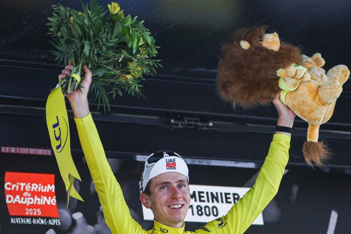 UAE Team Emirates XRG's Slovenian rider Tadej Pogačar celebrates wearing the overall leader's yellow jersey on the podium of the 7th stage of the 77th edition of the Criterium du Dauphine cycling race, 131,6 km between Grand-Aigueblanche and Valmeinier, on June 14, 2025. Anne-Christine POUJOULAT / AFP