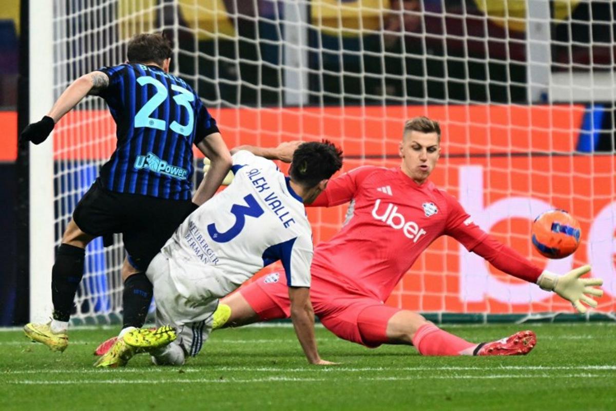 Inter Milan's Italian midfielder #23 Nicolo Barella tries to score against Como's French goalkeeper #01 Jean Butez during the Italian Serie A football match between Inter Milan and Como at San Siro stadium in Milan, on December 6, 2025. Stefano RELLANDINI / AFP