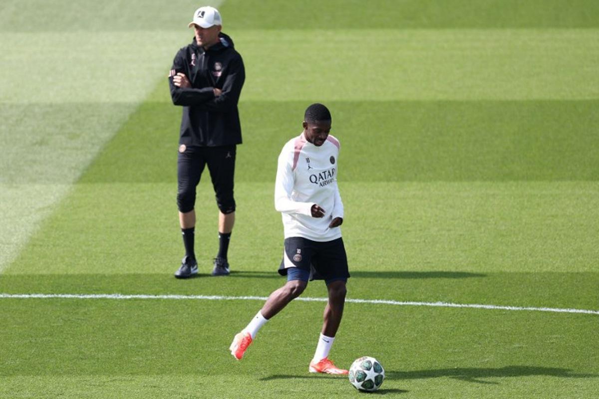 Paris Saint-Germain's French forward #10 Ousmane Dembele, next to Paris Saint-Germain's Spanish headcoach Luis Enrique (L), takes part in a training session on the eve of their second leg semi-final UEFA Champions League match against Arsenal, at the club's training ground in Poissy, west of Paris, on May 6, 2025. FRANCK FIFE / AFP