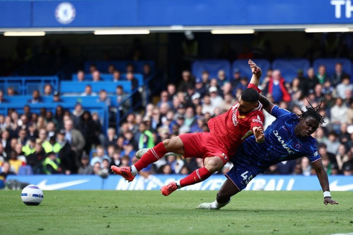 Liverpool's Egyptian striker #11 Mohamed Salah (C) is fouled by Chelsea's Belgian midfielder #45 Romeo Lavia (R) during the English Premier League football match between Chelsea and Liverpool at Stamford Bridge in London on May 4, 2025. HENRY NICHOLLS / AFP