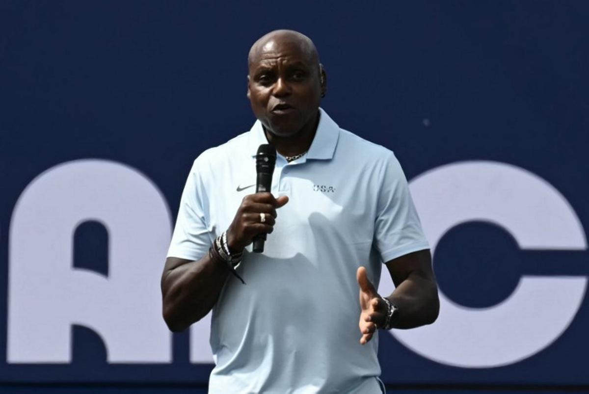 US former athlete Carl Lewis addresses guests on stage at the Champions Park at Trocadero during the Paris 2024 Olympic Games in Paris on August 9, 2024, with the Eiffel Tower visible in the background. CARL DE SOUZA / AFP