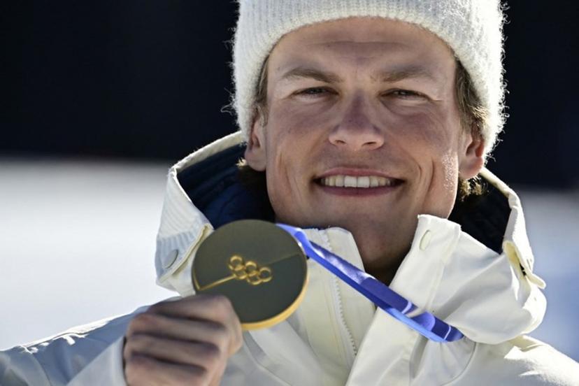 Gold medallist Norway's Johannes Hoesflot Klaebo celebrates on the podium for the men's 10km cross-country interval start free event of the Milano Cortina 2026 Winter Olympic Games at Tesero Cross-Country Skiing Stadium in Lago di Tesero (Val di Fiemme) on February 13, 2026. Tobias SCHWARZ / AFP